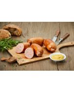 Knacker in goldbrauner Pelle, halbiert und ganz auf rustikalem Holzbrett drapiert, daneben keramikbesetztes Besteck (Messer & Gabel), weiße Senfschale, frische Petersilienzweige und grobes Körnerbrot.